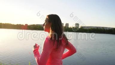 日落时分，女人穿过<strong>湖岸</strong>上的公园，慢动作